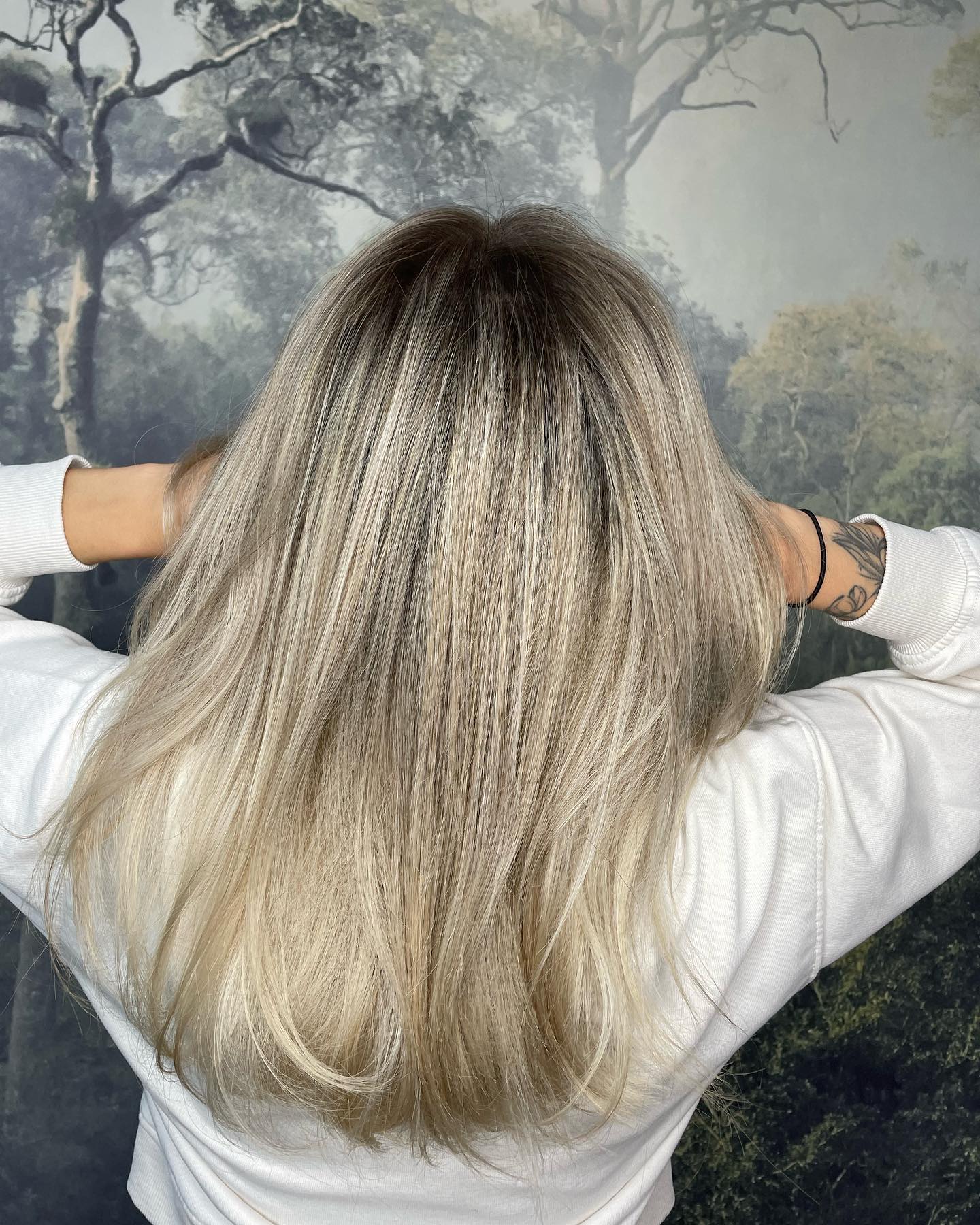 Platinum blonde balayage with a lived-in root and natural texture