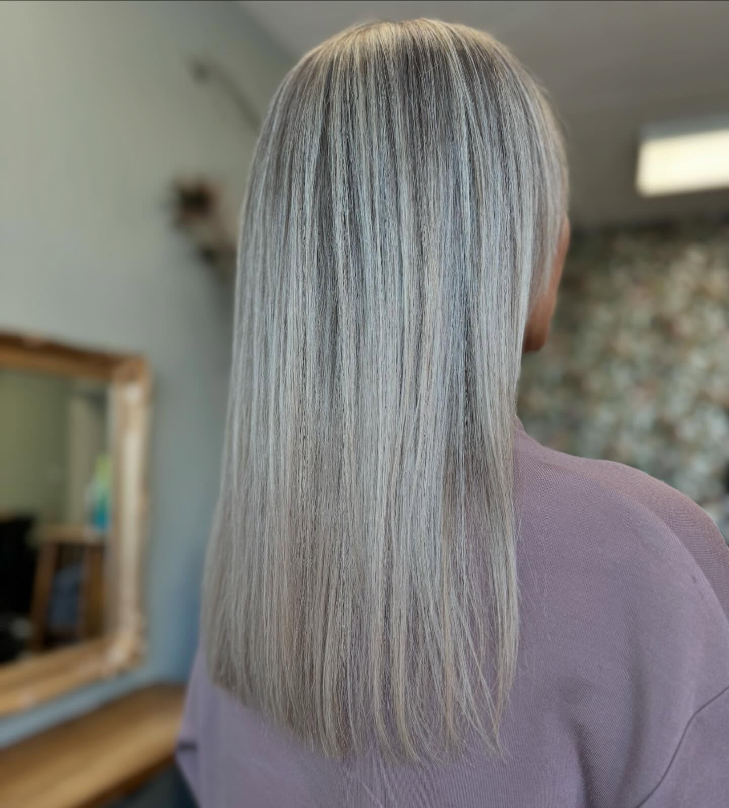 Cool-toned icy blonde hair with a sleek straight finish and high shine