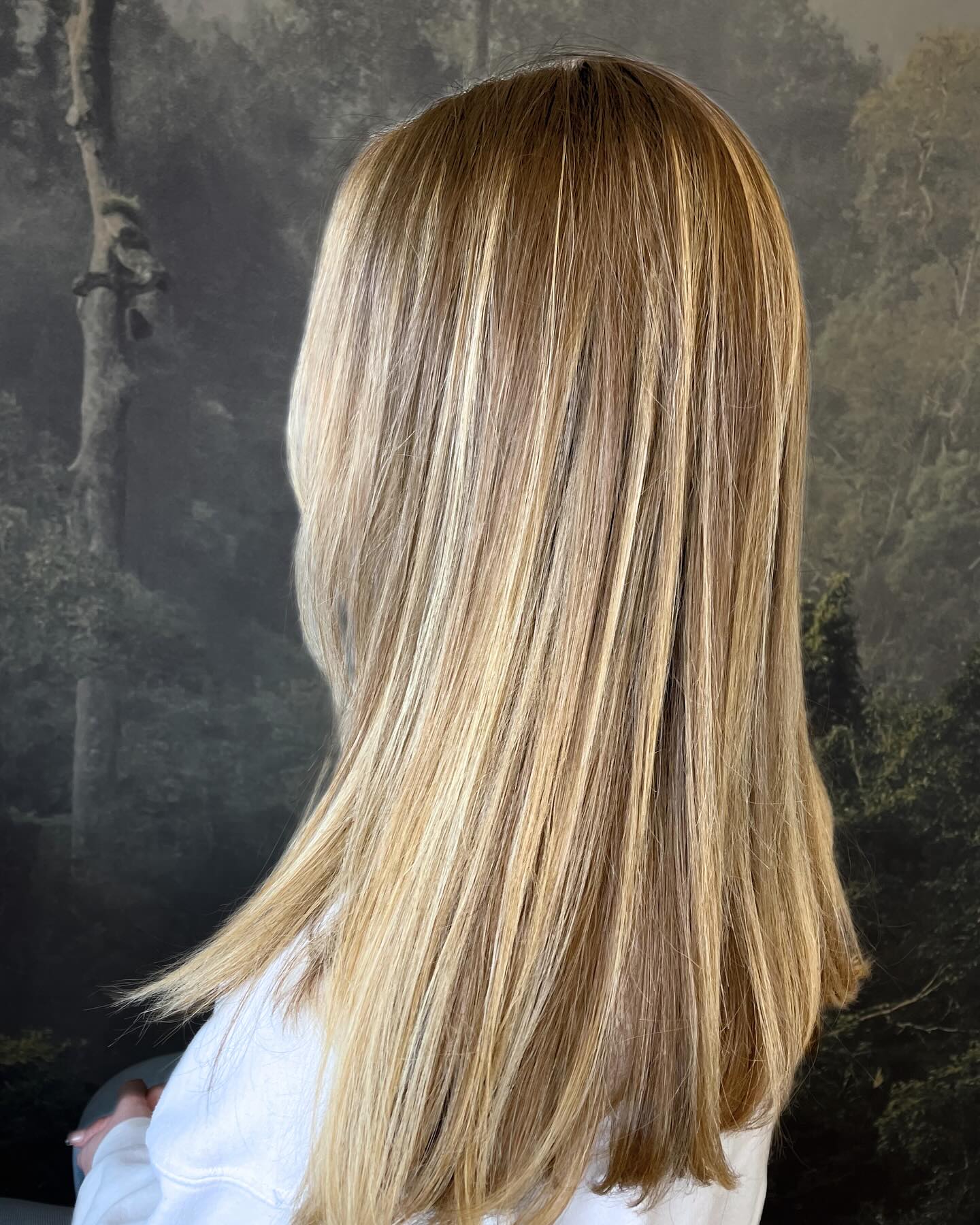 Soft blonde highlights with natural dimension and a shoulder-length cut
