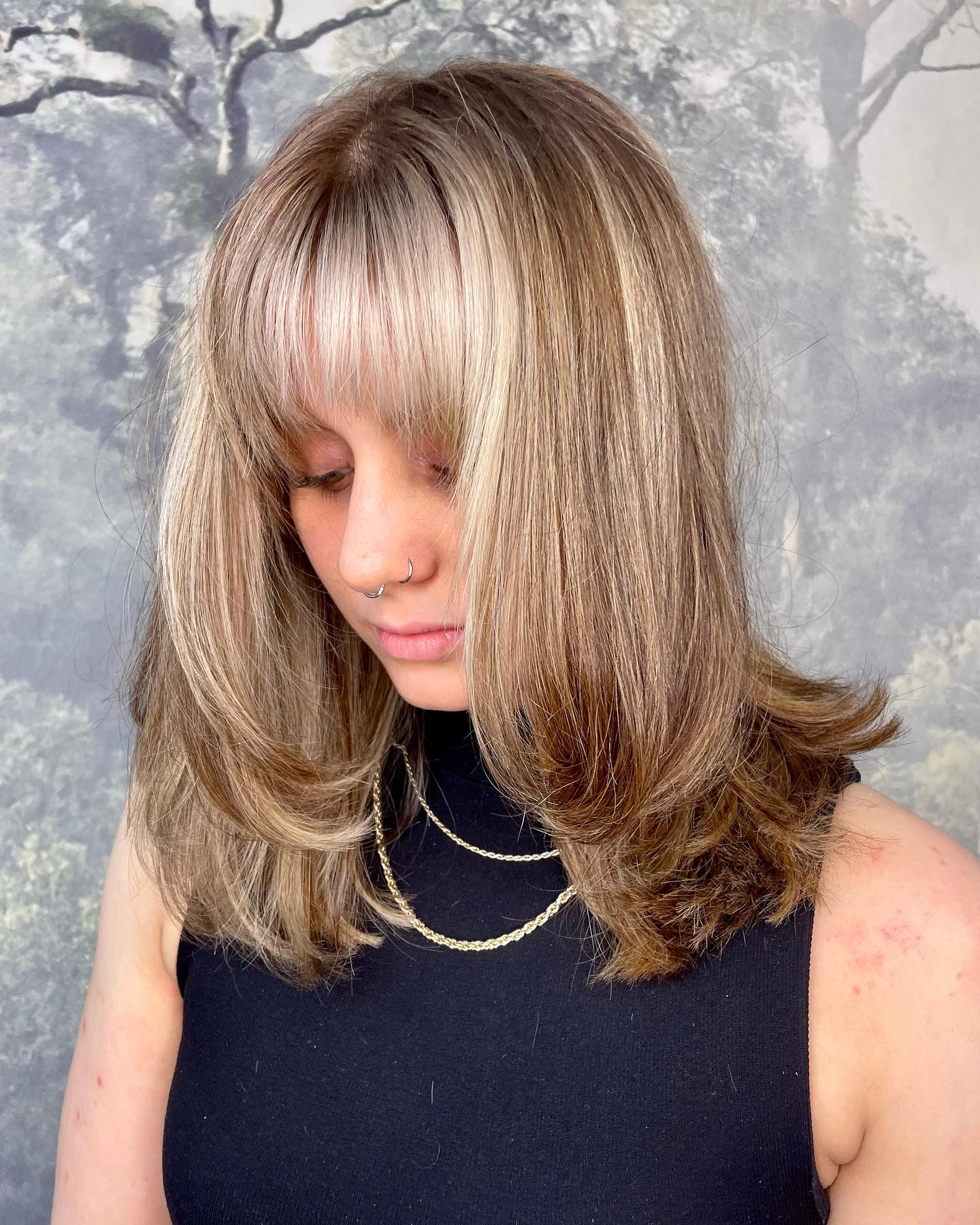Layered blonde hair with a curtain fringe and soft face-framing shape