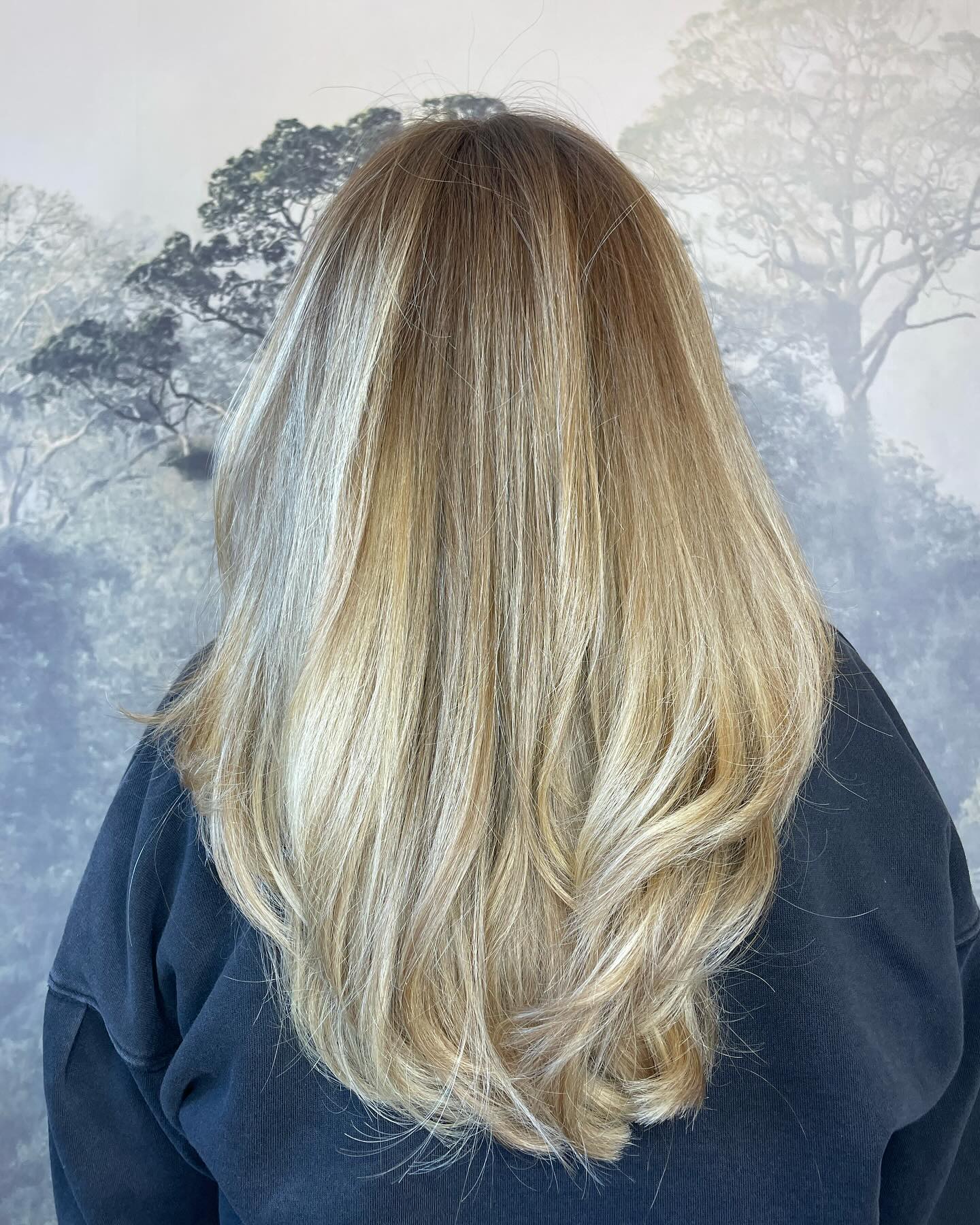 Long blonde hair with a layered cut and natural dimension